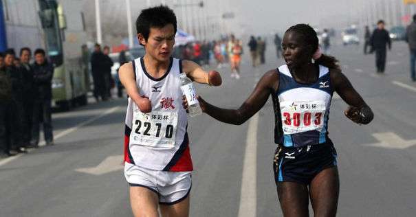Jacqueline Kiplimo helps a disabled runner to finish his marathon