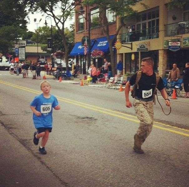 Marine Myles Kerr supports a young boy to finish his race 